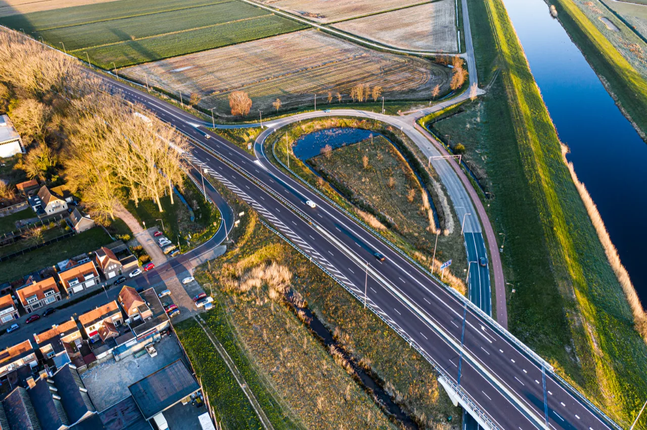 Rijksweg door de polder in het late licht, vanuit de lucht