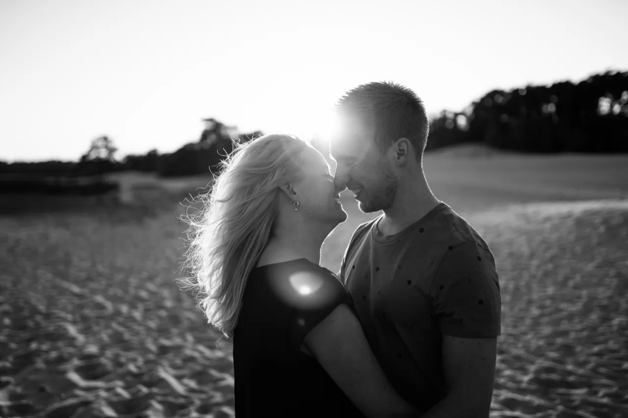 Stel op het strand in tegenlicht, zwart-wit