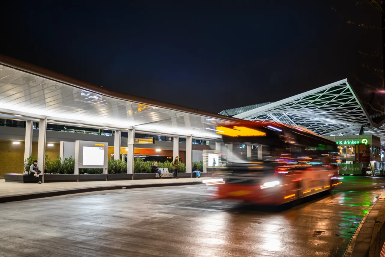 Busstation bij avond, met bewegingsonscherpte