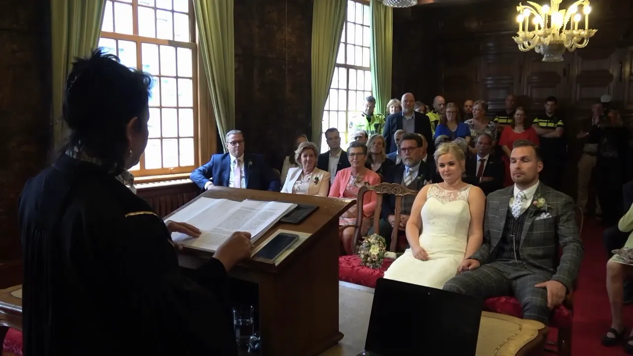 Het bruidspaar tijdens de ceremonie in de trouwzaal